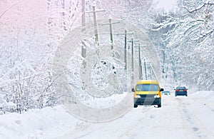 Snow covered road. Yellow car on a snowy road.