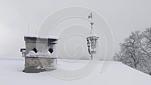 Snow Covered Roof in Winter with Chimney and Weather Cock