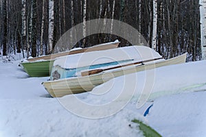 Snow covered rowboats on a beach photo