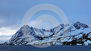 Snow covered rugged mountain at Sundstraumen on the Lofoten in winter in Norway