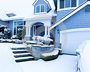 Snow covered sidewalk in front of home during winter snowfall