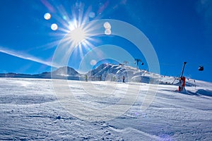Snow-Covered Ski Slope and Ski Lift and Bright Sun