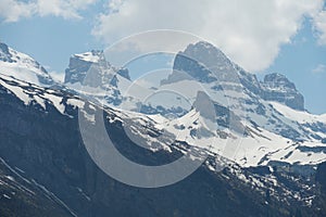 Snow covered slopes of the Alps in the spring in Region of Engelberg canton Obwalden in Switzerland with white clouds on the backg