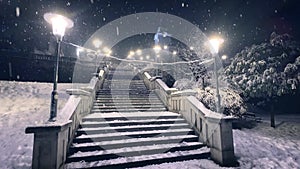 Snow covered stairs lit by glowing night lamps.