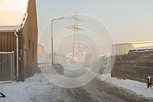 Snow covered streets between farms and house in winter cityscape