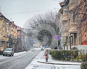 Snow covered streets of the winter old town, frosty weather, a woman alone with an umbrella Uzhhorod Uzhgorod