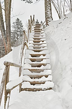 Snow-covered tourist stairs woods