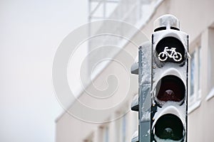 Snow-covered traffic light for bicycles against the building, Finland