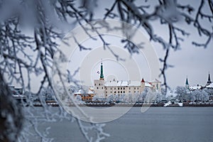 Snow-covered trees and view of the Riga Castle.