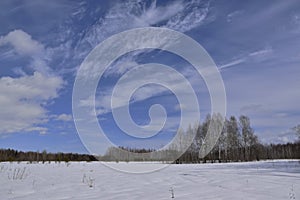 Snow-covered Ural forest under the blue March sky. Spring in the foothills of the Western Urals.