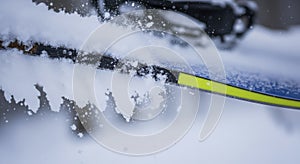 Snow covered windshield with ice scraper