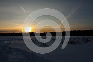 Snow covered winter forest at sunset