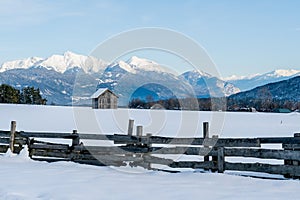 Snow covered winter landscape with barn and view on the alpine mountain `Hohe Munde`, Mieming, Tirol, Austria