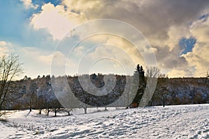 Snow covered winter landscape in German Odenwald forest with backlight sunlight