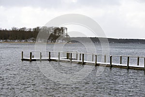 Snow-covered wooden bridge in the sea