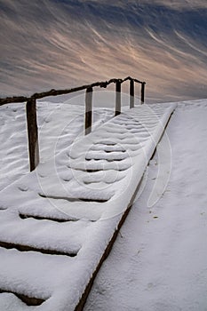 Snow covered wooden stair