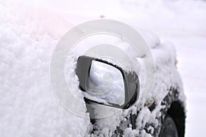 Snow cowered car on a parking lot.