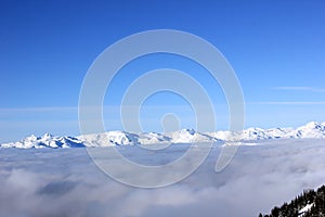 Snow-cowered mountains over the fog