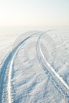 Snow desert and the tracks of the car in the snow