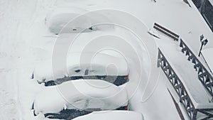 Snow drifts in the car park. Cars are covered with snow. Snow drifts. Heavy snowfall.