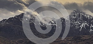 Snow Dusted Mountain Range Capped in Clouds