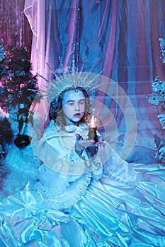 Snow fairy in the forest holds a lamp with fire in her hands. fabulous decoration