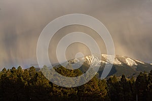 Snow falling on mountains at sunset. Flagstaff, Arizona.