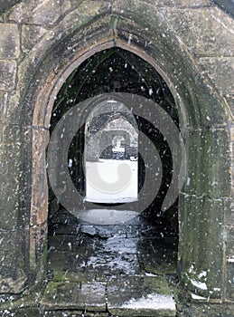 Snow falling in the ruins of heptonstall church doorway