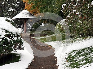 Snow falling on sidewalk in Japanese garden photo
