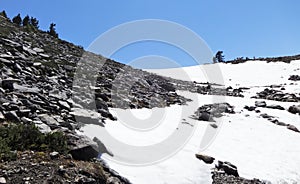 A snow field on a hiking trail in summer