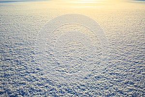 Snow field sparkling in the sun, surface snow texture with glittering shine. Christmas natural background. Winter specific.