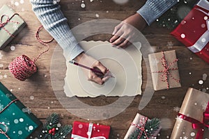 Snow flakes falling upon gifts on a wooden table-banner with copy space