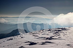 Snow formations on barren ridge in Velka Fatra above blue mist