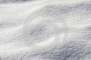 Snow. Fresh white snow surface. Winter texture. Snow background and wallpaper. Bright light in the snow. Snowflakes.