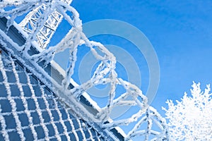 snow and frost on a metal fence made of mesh