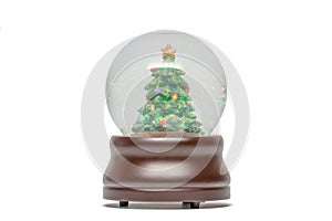 Snow globe of green Christmas tree with glittery sparkles visible - brown wood base -  isolated on white