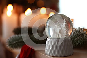 Snow globe on wooden table against background. Space for text