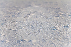 Snow grains close up. Blurred in the distance.