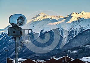 Snow gun about of cottages in mountains