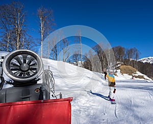 Snow Gun and snowboarder woman in mountains