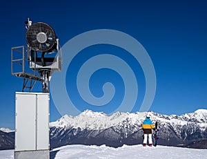 Snow Gun and snowboarder woman in mountains