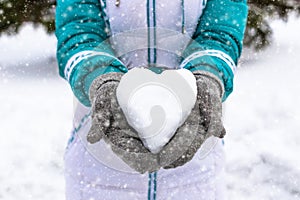 Snow heart in woman's heand. Winter romantic concept