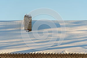 Snow and ice on the roofs of buildings. Icicles hang from the roofs of houses. The probability of the roof collapsing under the