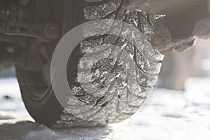 a snow and ice winter car tyres. close up auto vehicle wheel