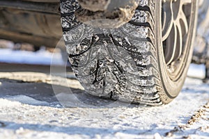 a snow and ice winter car tyres. close up auto vehicle wheel