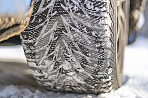 a snow and ice winter car tyres. close up auto vehicle wheel