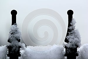 Snow on iron gate posts