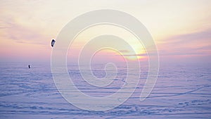 Snow kiteboarder in a snowy field