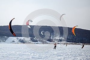 Snow kiting on a snowboard on a frozen lake