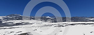 Snow landscape with hills and blue sky